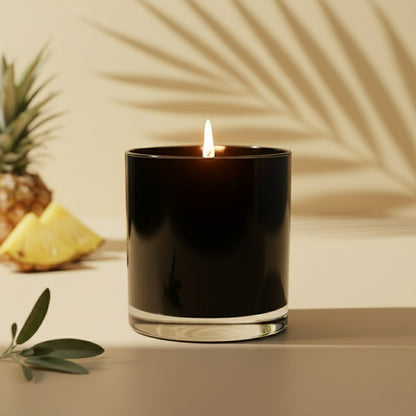 Black candle with a flame on a neutral background with a pineapple and leaves.