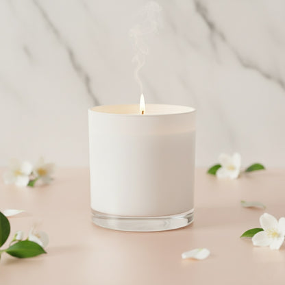 White glass Wellscentd Neroli & White Jasmine Candle lit on marble surface surrounded by fresh jasmine petals.