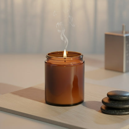 Brown candle with a small flame on a wooden surface with stones and a box in the background.