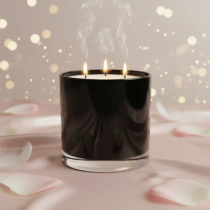 Black candle with three flames on a soft pink background with blurred lights