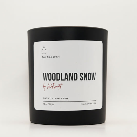 Black candle with 'Woodland Snow' label on a white background