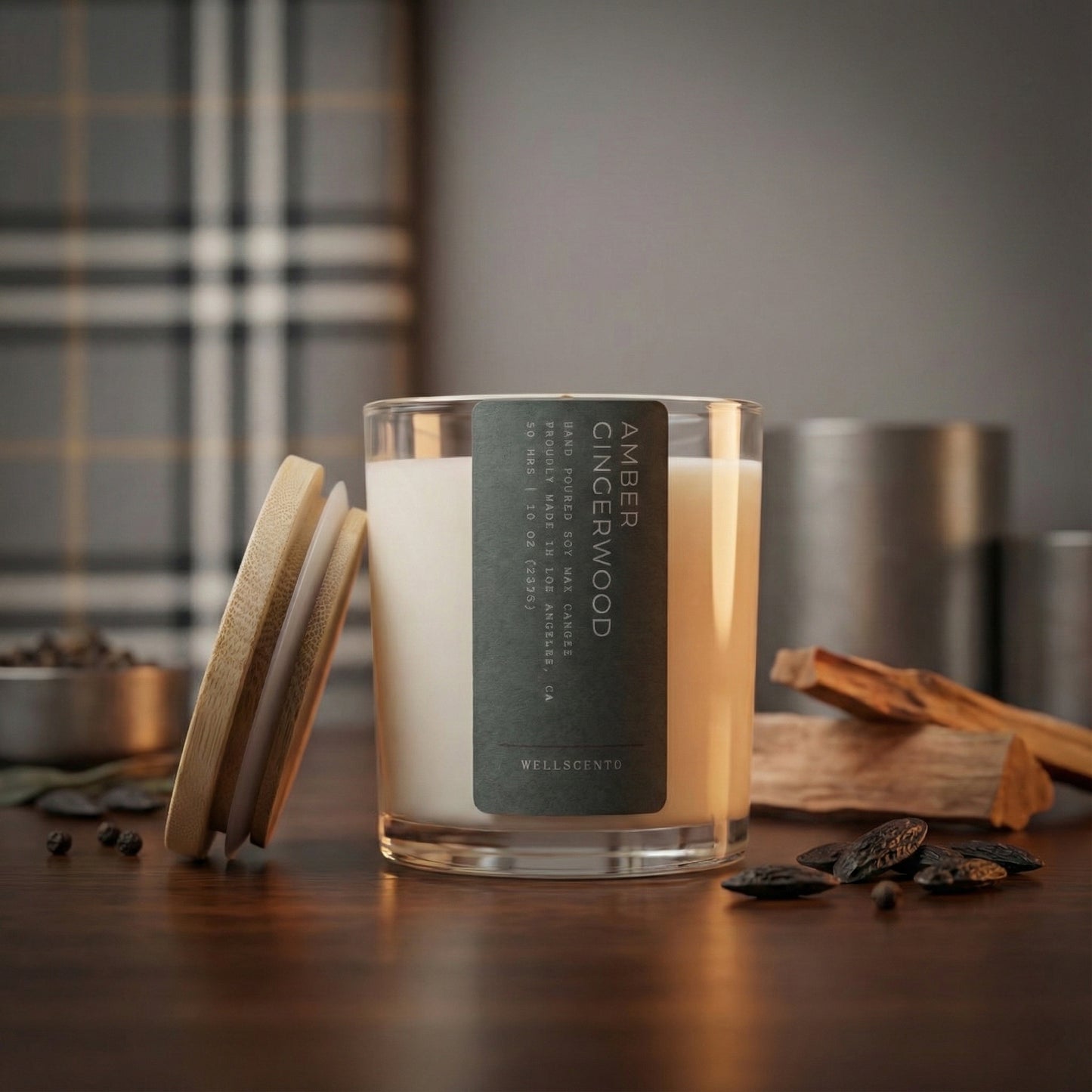 Candle with a label on a wooden surface, surrounded by cinnamon sticks and spices.