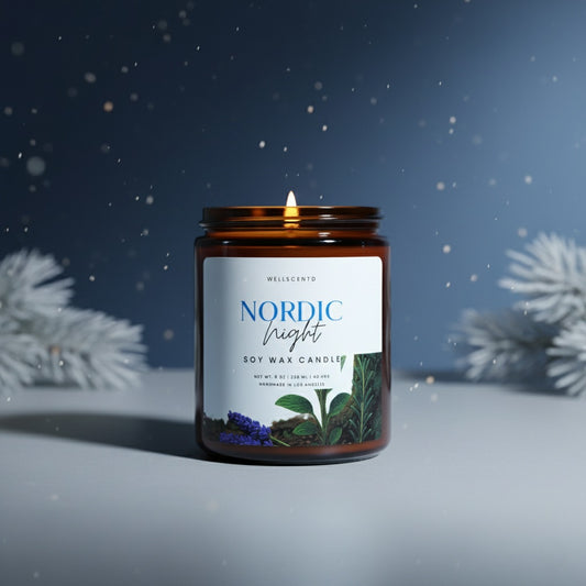 Nordic Night candle in a snowy setting with evergreen branches.