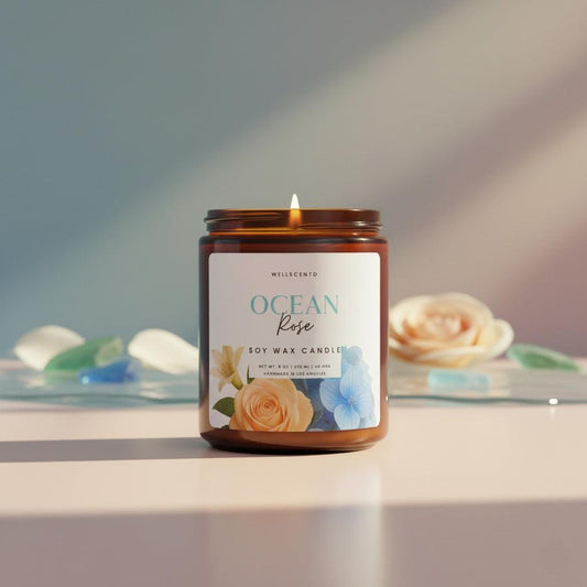 8oz Wellscentd Ocean Rose Candle in an amber jar, styled on a table with coastal decor.