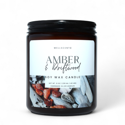 Soy wax candle labeled 'Amber & Driftwood' by Wellscento on a white background