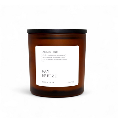 Wellscentd Bay Breeze candle in amber glass jar with black lid – 18oz soy wax, fresh coastal scent, white minimalist label, product photo on white background.