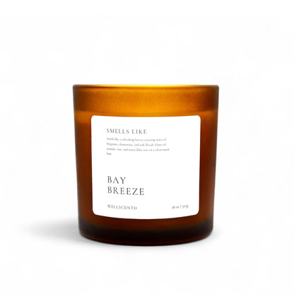 Wellscentd Bay Breeze scented candle in amber glass jar – 18oz soy wax blend, crisp bergamot and water lily fragrance, styled product image on white background.