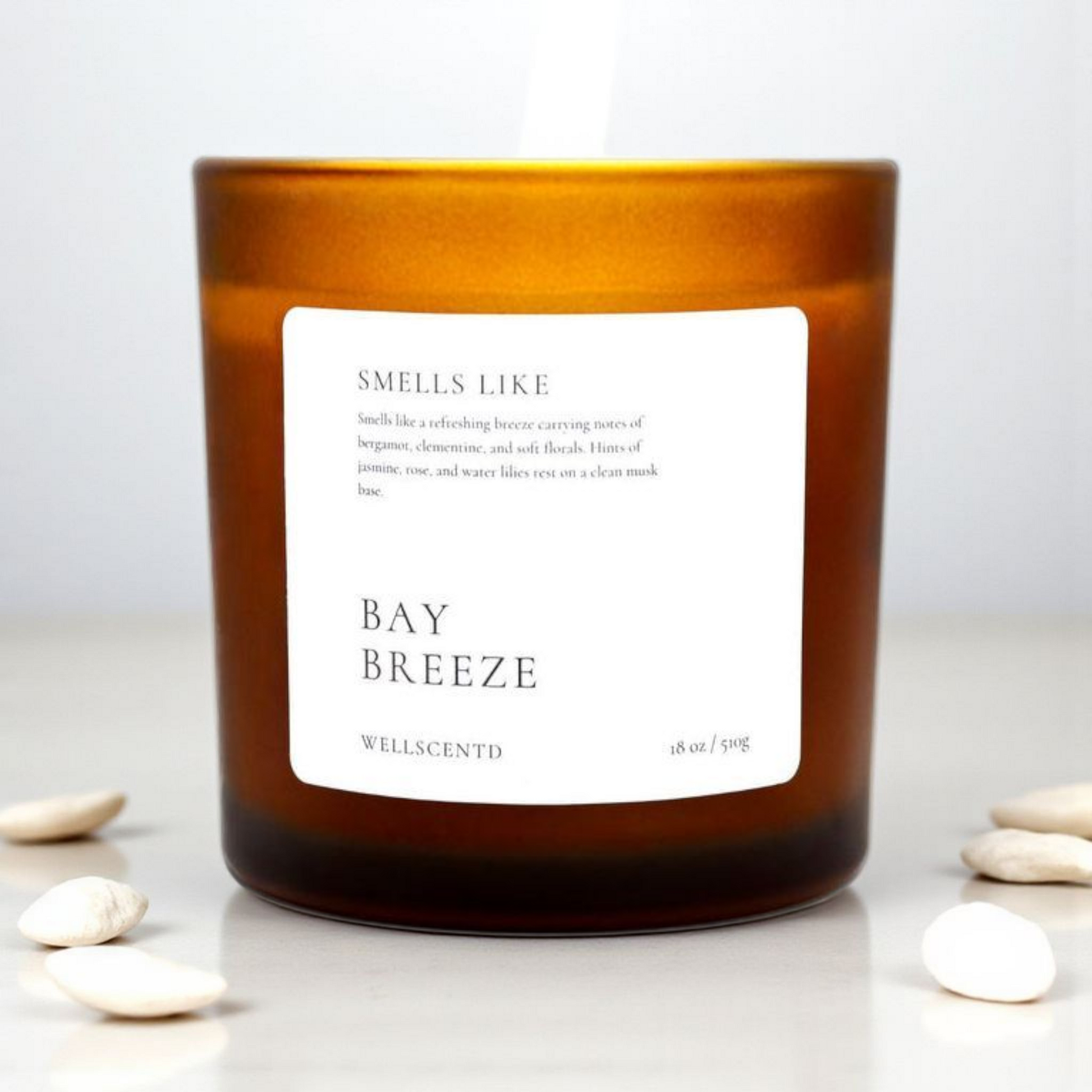 Candle with a label indicating 'Smells Like Bay Breeze' by Wellacento on a white background.